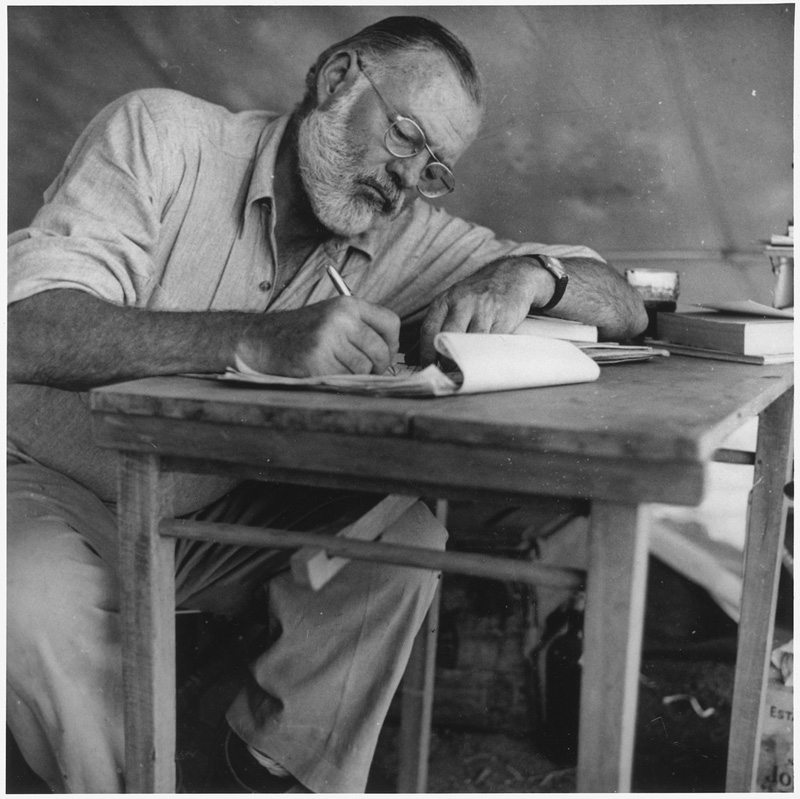 lossy-page1-1025px-Ernest_Hemingway_Writing_at_Campsite_in_Kenya_-_NARA_-_192655.tif