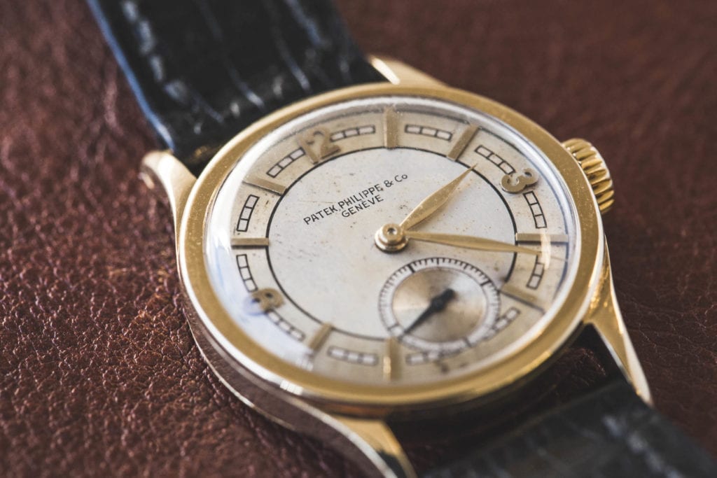 A Patek Philippe Watch, gold case, cream dial, and black strap 