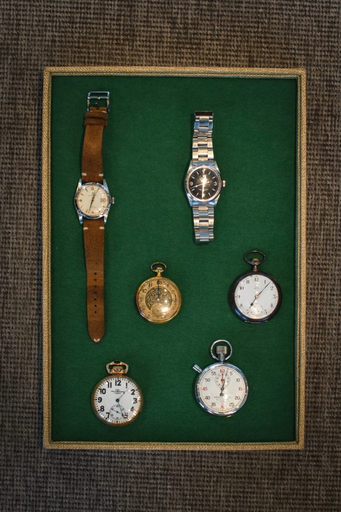 Sid Mashburn's watches laying on a green tray 