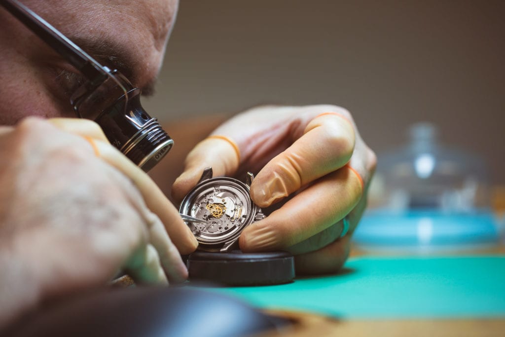 Watchmaker inspecting a movement